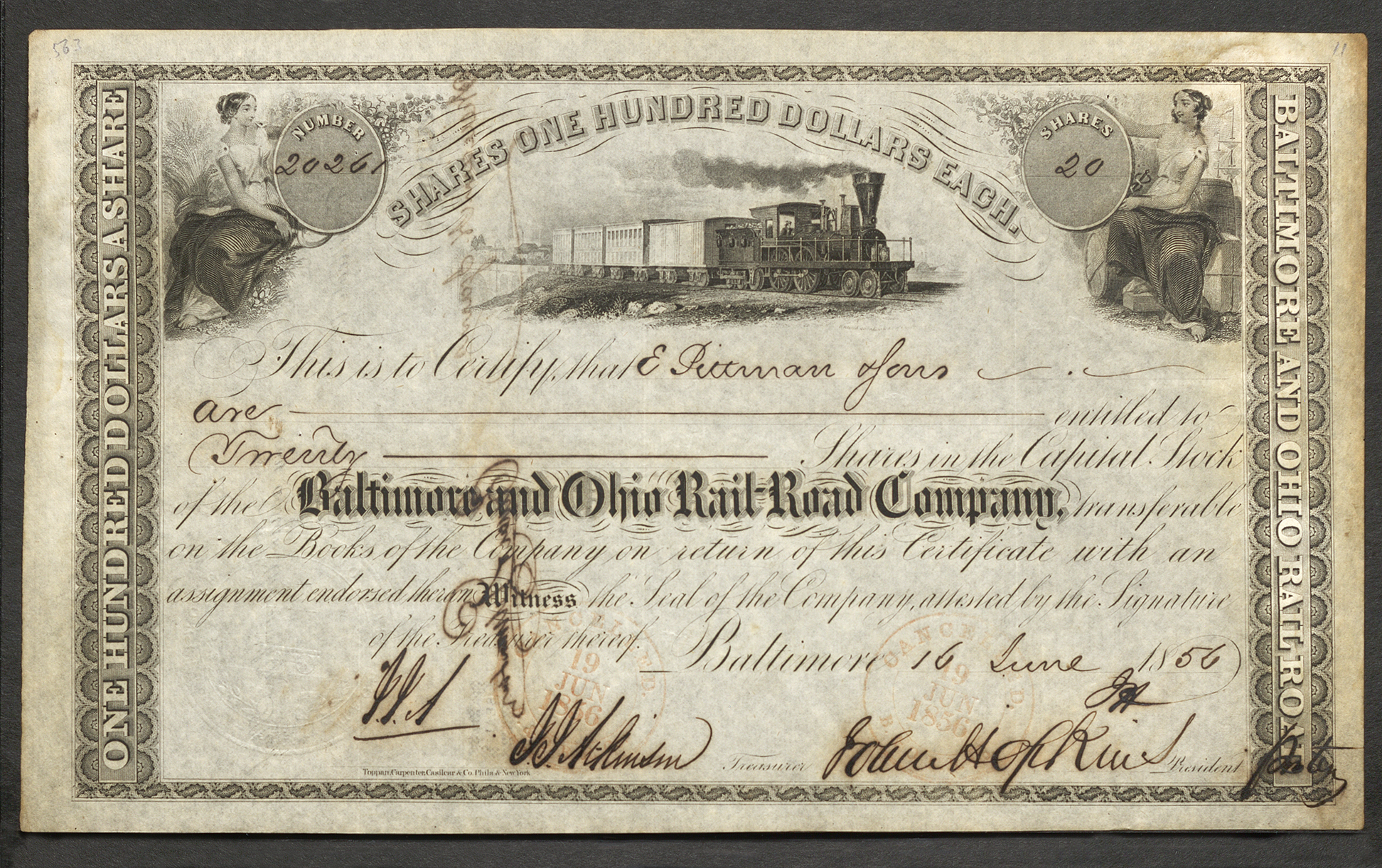 This stock certificate (No. 20261) represents 20 shares valued at $100 each for the Baltimore and Ohio Railroad Company. Two vignettes in the top corners each feature a woman dressed in a white dress with a blanket draped over her knees. The left woman is sitting on a bushel of wheat and is holding a hand scythe, and the right woman is sitting on several barrels and boxes holding a rapier-looking rod. The center vignette depicts a train with five cars linked and a bridge and several buildings behind it. This certificate also shows the company’s corporate seal and two stamps denoting cancellation (see Translation field for more).
